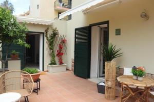 a patio with a green door and tables and chairs at Residència Mediterrània Alguer in Alghero