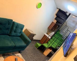 a living room with a green couch and a tv at Perfect Homes Namugongo in Kasiyirize