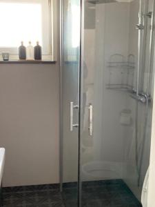 a shower with a glass door in a bathroom at Känslans in Årjäng +14 photos
