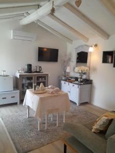a living room with a table and a kitchen at Cortile Fiorito Bed and Breakfast mini appartamento in Gorizia