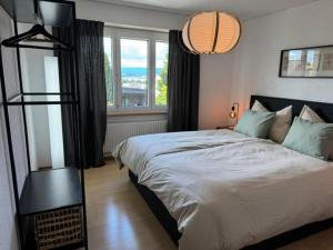 a bedroom with a large bed and a large window at inHome Vista Murten in Murten