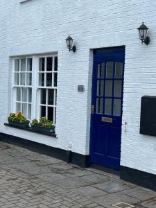 a blue door and windows on a white brick building at The Ship Inn's Cabin in Gatehouse of Fleet +3 photos