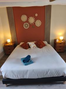 a bedroom with a large white bed with two night stands at Gite de la perle rouge in Rodelinghem