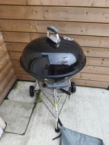a charcoal grill in front of a wooden wall at Gite de la perle rouge in Rodelinghem