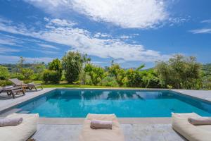 a swimming pool with two lounge chairs next to at Spartakos Villa Resort - Slow Living Retreat collections With Private Pools in Planos