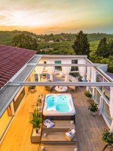 an outdoor deck with a hot tub on a house at Spartakos Villa Resort - Slow Living Retreat collections With Private Pools in Planos