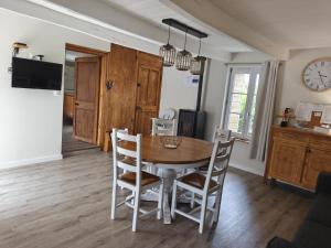 a kitchen and dining room with a table and chairs at Gite de la perle rouge in Rodelinghem