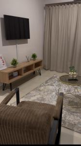 a living room with a tv and a couch at The Fig Central Apartments in Gaborone