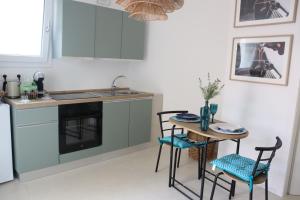 a kitchen with a table and chairs and a sink at Residència Mediterrània Alguer in Alghero