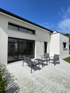 a patio with chairs and a table in front of a house at Le Cottage Bigouden in Combrit +22 photos