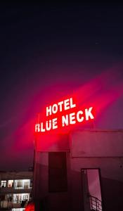 a neon sign on the side of a building at Hotel Blue Neck in Patna
