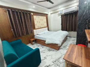 a bedroom with a bed and a blue couch at Hotel Blue Neck in Patna