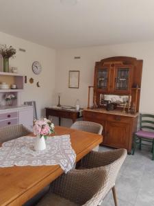 a dining room with a table with a vase of flowers on it at Cortile Fiorito Bed and Breakfast mini appartamento in Gorizia