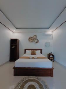 a bedroom with a large bed with a ceiling at Batur Tropical in Kintamani