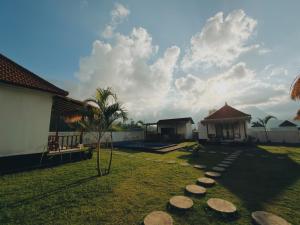 a yard with a gazebo and rocks on the grass at Batur Tropical in Kintamani