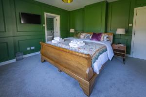 a bedroom with a large bed with green walls at Casa Sona in Spean Bridge