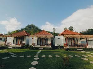 a row of cottages with a grass yard at Batur Tropical in Kintamani