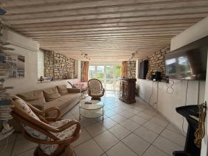 a living room with a couch and a table and a tv at The Grimme Residence in Xiropigado