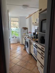 a kitchen with a washer and dryer on a tile floor at The Grimme Residence in Xiropigado
