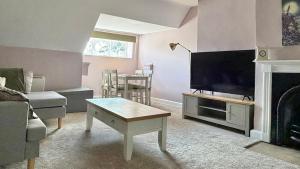 a living room with a tv and a couch and a table at Bleasby Hall - Kelham Suite B&B in Bleasby
