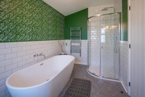 a bathroom with a tub and a green wall at Casa Sona in Spean Bridge