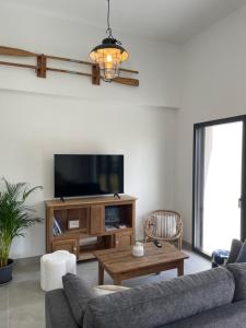 a living room with a couch and a tv at Le Cottage Bigouden in Combrit