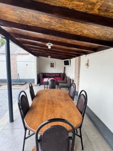 a wooden table and chairs in a room with a couch at Fir Tree Villa in Chişinău