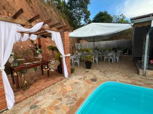 a patio with a pool and a table and a tent at Chácara sonho meu in Jacutinga