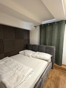 two beds in a room with green curtains at Slavia penzion in Mikulov