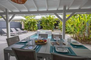 a table with plates of food on a patio at Majesty Palm Hôtel in Saint-François