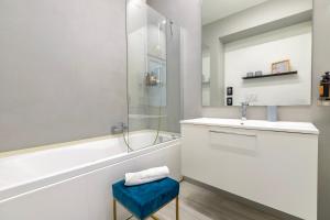 a bathroom with a tub and a sink and a mirror at RelaisApartments PORTO in Alghero