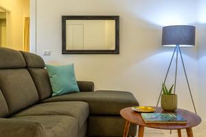 a living room with a couch and a table at RelaisApartments PORTO in Alghero