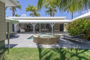 a backyard with a swimming pool and a house at Majesty Palm Hôtel in Saint-François