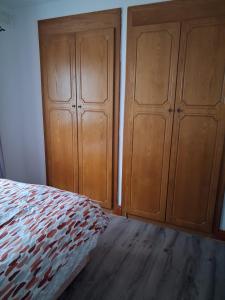 a bedroom with two wooden cabinets and a bed at Teach Caitlin in Ballina