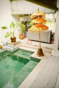 a pool of water in a living room with a table at Unique 2BR Gianyar Villa Rice Field View & Pool in Blahbatu