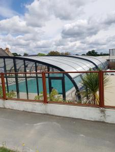 a building with a curved roof with plants in it at Location mobil home in Litteau