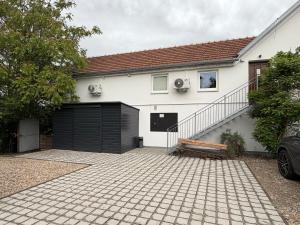 a white house with a garage and a bench at Slavia penzion in Mikulov +21 photos