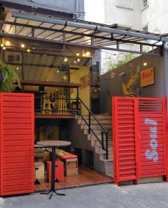a restaurant with red doors and a table and stairs at Soul Hostel Av Paulista Bela Vista 1 in São Paulo