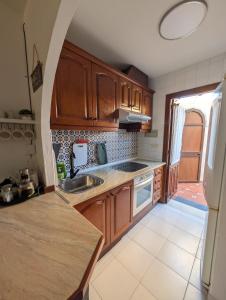 a kitchen with wooden cabinets and a sink at Jardín secreto del Mar Menor, La Manga in San Javier +18 photos