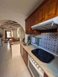 a kitchen with wooden cabinets and a counter top at Jardín secreto del Mar Menor, La Manga in San Javier