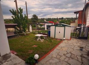 a small yard with a bench and a shed at Greek Hacienda in Nea Kallikrateia +5 photos