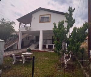 a white house with a fence in front of it at Greek Hacienda in Nea Kallikrateia