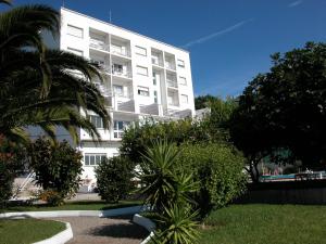 ein weißes Gebäude mit einer Palme davor in der Unterkunft Hotel Touris in O Grove