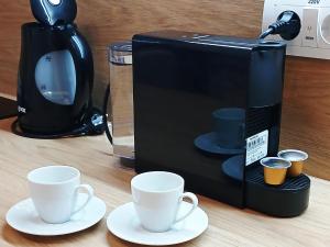 a microwave with two coffee cups on a table at Apartman Aurelia in Sremska Mitrovica