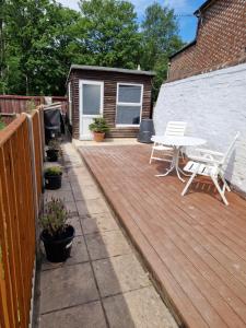 a patio with a table and chairs on a deck at Carisbrooke Mill Cottage in Newport +11 photos