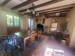 a dining room with a table and chairs and a fireplace at Lekker Slaap in Parthenay