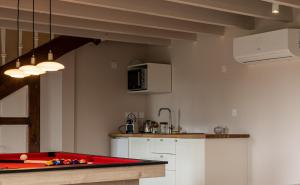 a kitchen with a red pool table in a room at L'étincelle secrète - gîte romantique entre cordes et Najac in Le Ségur-Suech
