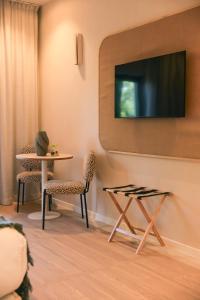 a living room with a table and chairs and a tv at Maison Provence in Saint-Tropez