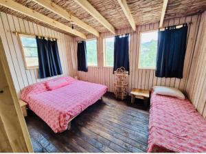 a bedroom with two beds in a room with windows at Casa Luna in Maitencillo