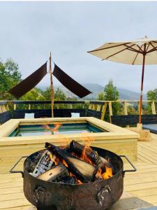 a barbecue grill with a pool and an umbrella at Casa Luna in Maitencillo